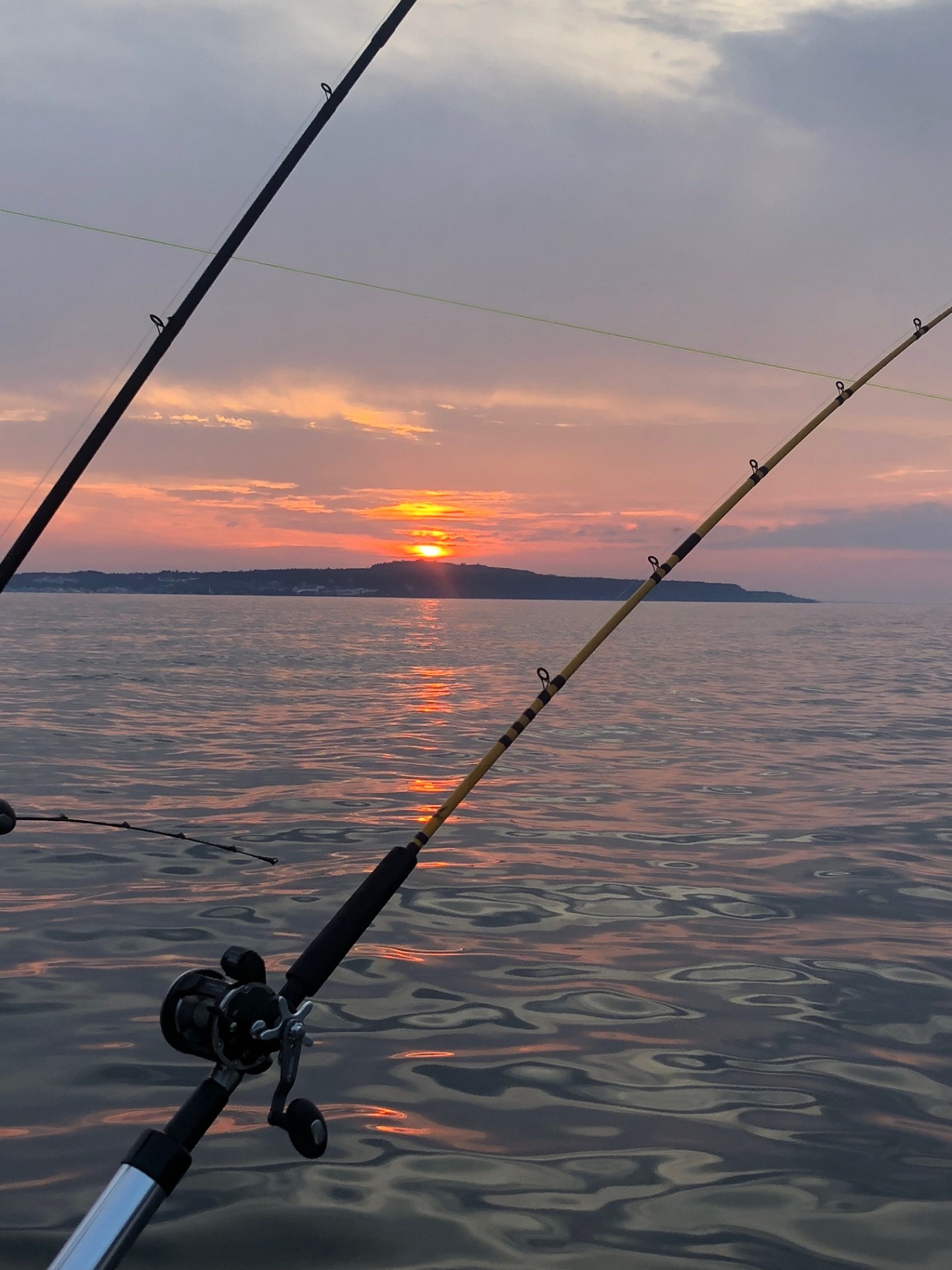 Fishing rods at vivid orange and pink sunset