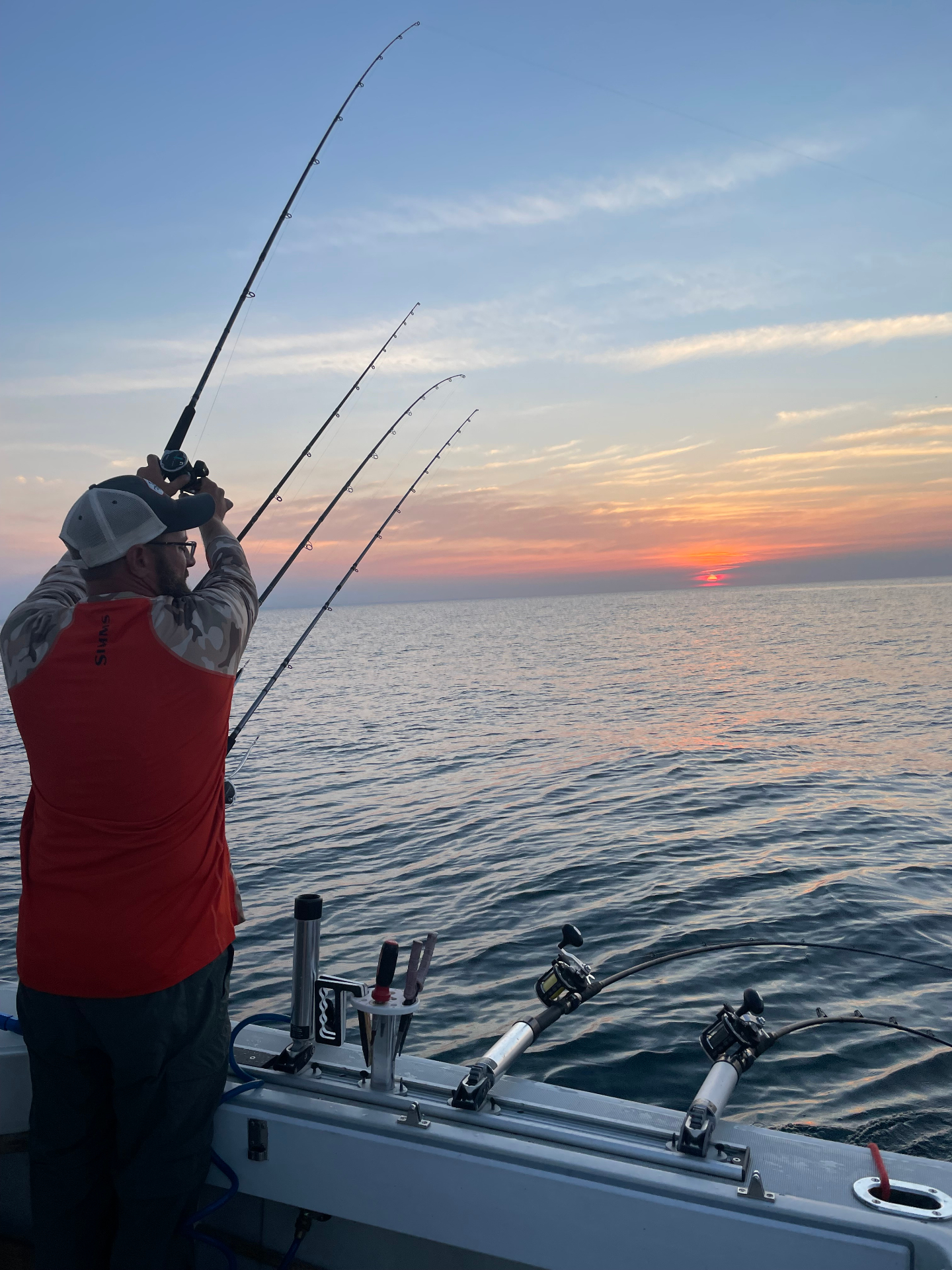 Orange sunrise over northern Michigan fishing water